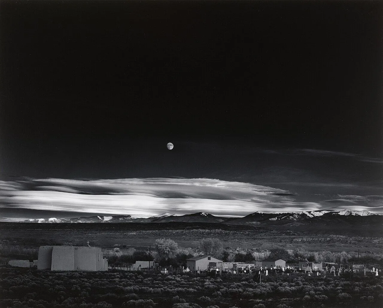 Ảnh &quot;Moonrise, Hernandez, New Mexico&quot; của Ansel Adams, nổi tiếng với kỹ thuật tương phản và màu đen trắng đặc trưng.