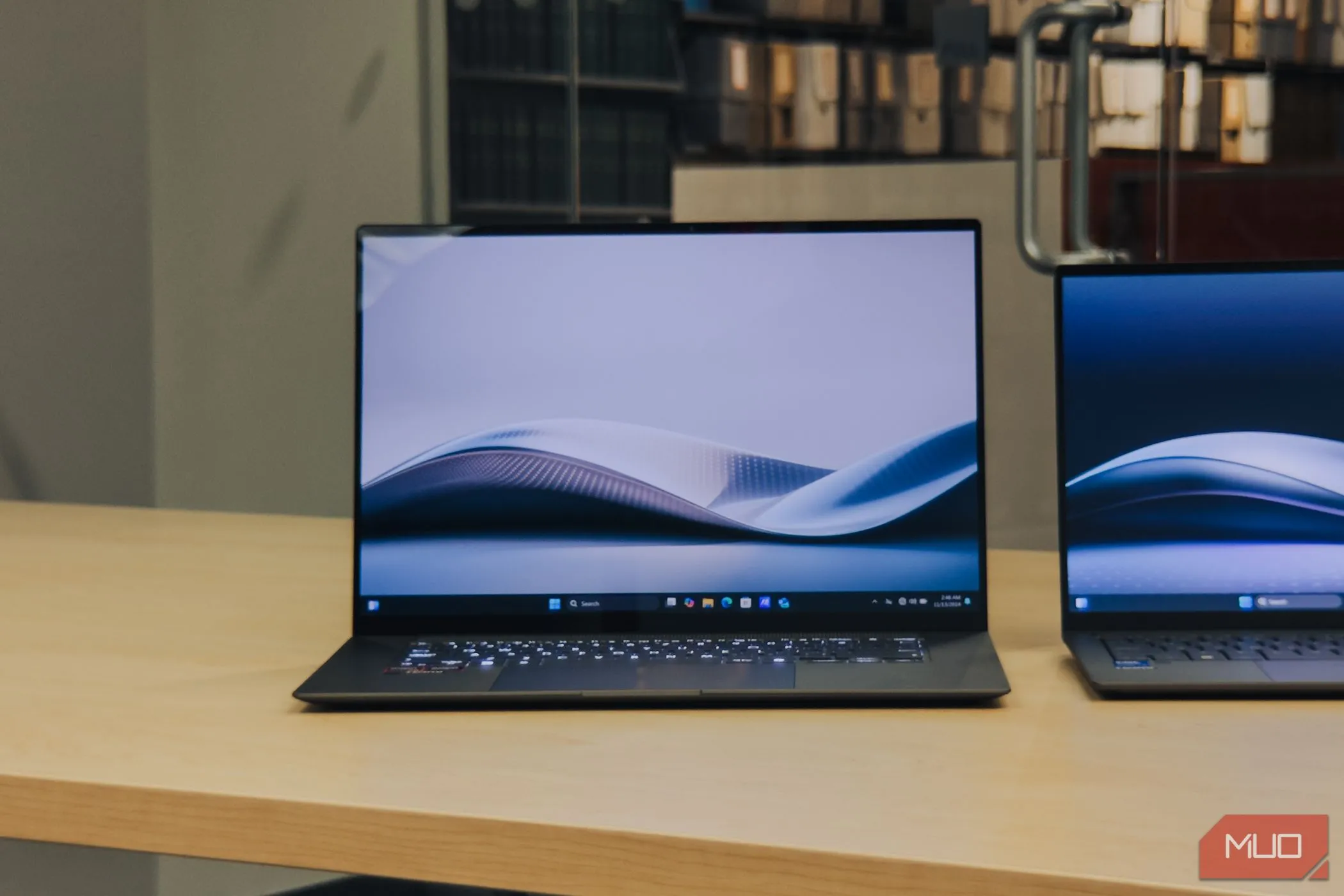 ASUS Zenbook S 16 OLED trên bàn gỗ với màn hình đang bật