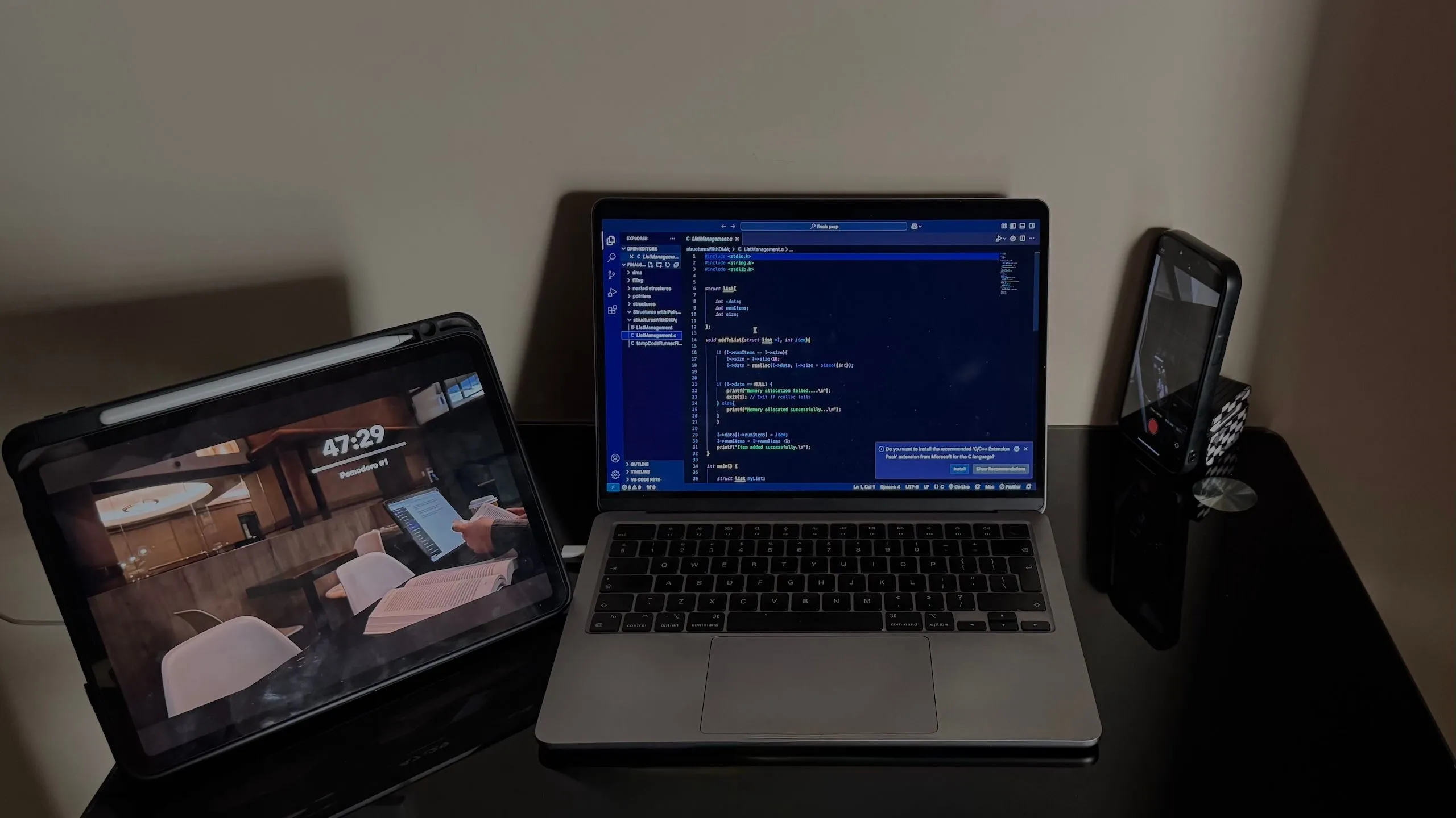 Bàn làm việc với iPad, iPhone và MacBook, minh họa khả năng kết nối đa thiết bị của bàn phím