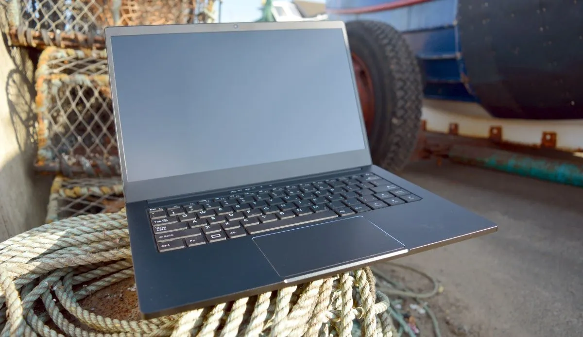 Chiếc laptop Purism Librem đặt trên nền đất gần xe cơ giới, thể hiện thiết kế bền bỉ và tính di động của dòng máy tính bảo mật cao với các công tắc ngắt vật lý.