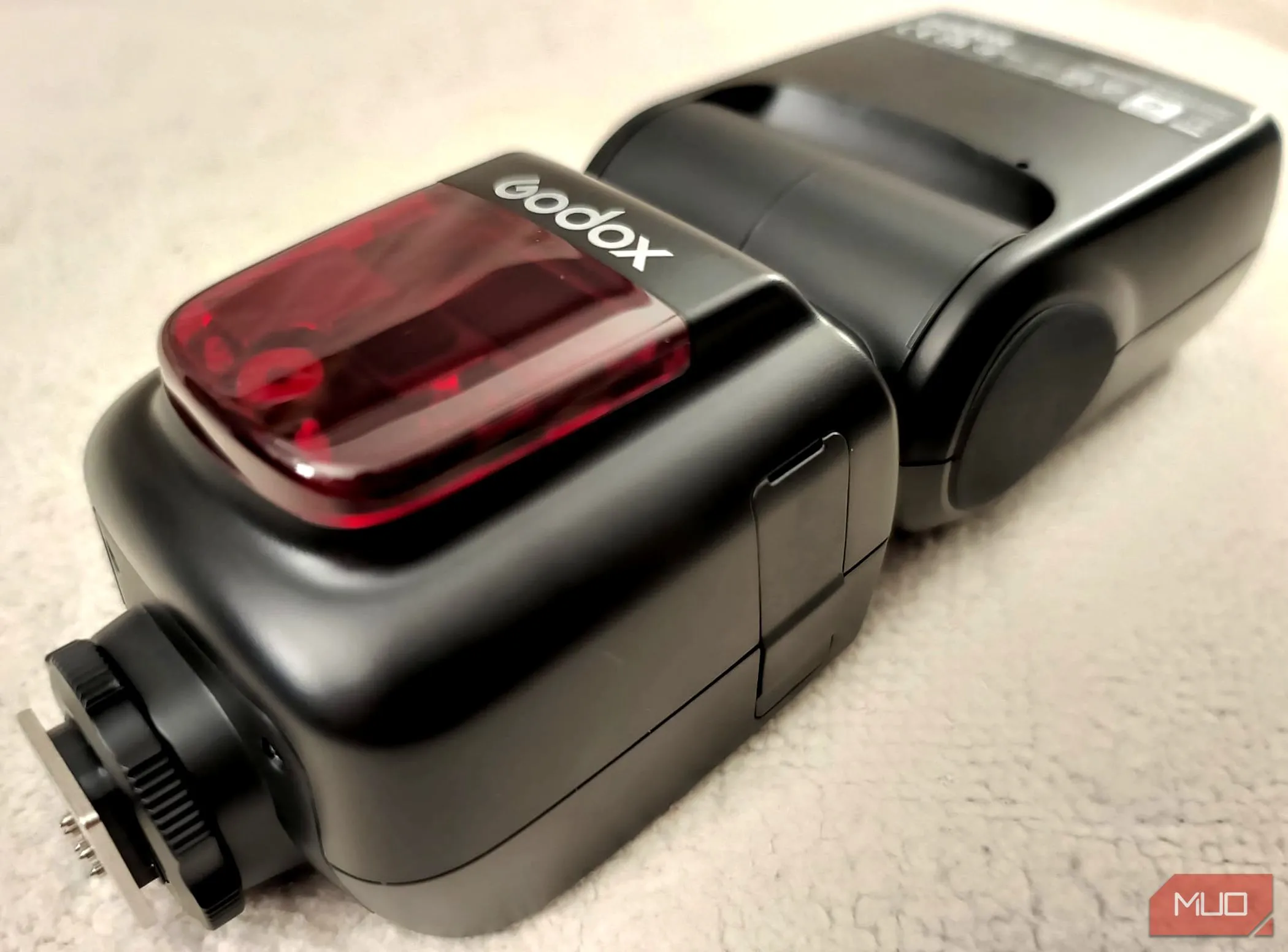 Đèn flash Godox V860II-C đặt trên nền vải, thể hiện thiết kế bền bỉ và chất lượng hoàn thiện của dòng đèn flash Godox