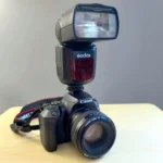Đèn flash Godox V860II gắn trên thân máy ảnh chuyên nghiệp, minh họa khả năng kết nối và sử dụng thực tế của đèn flash Godox