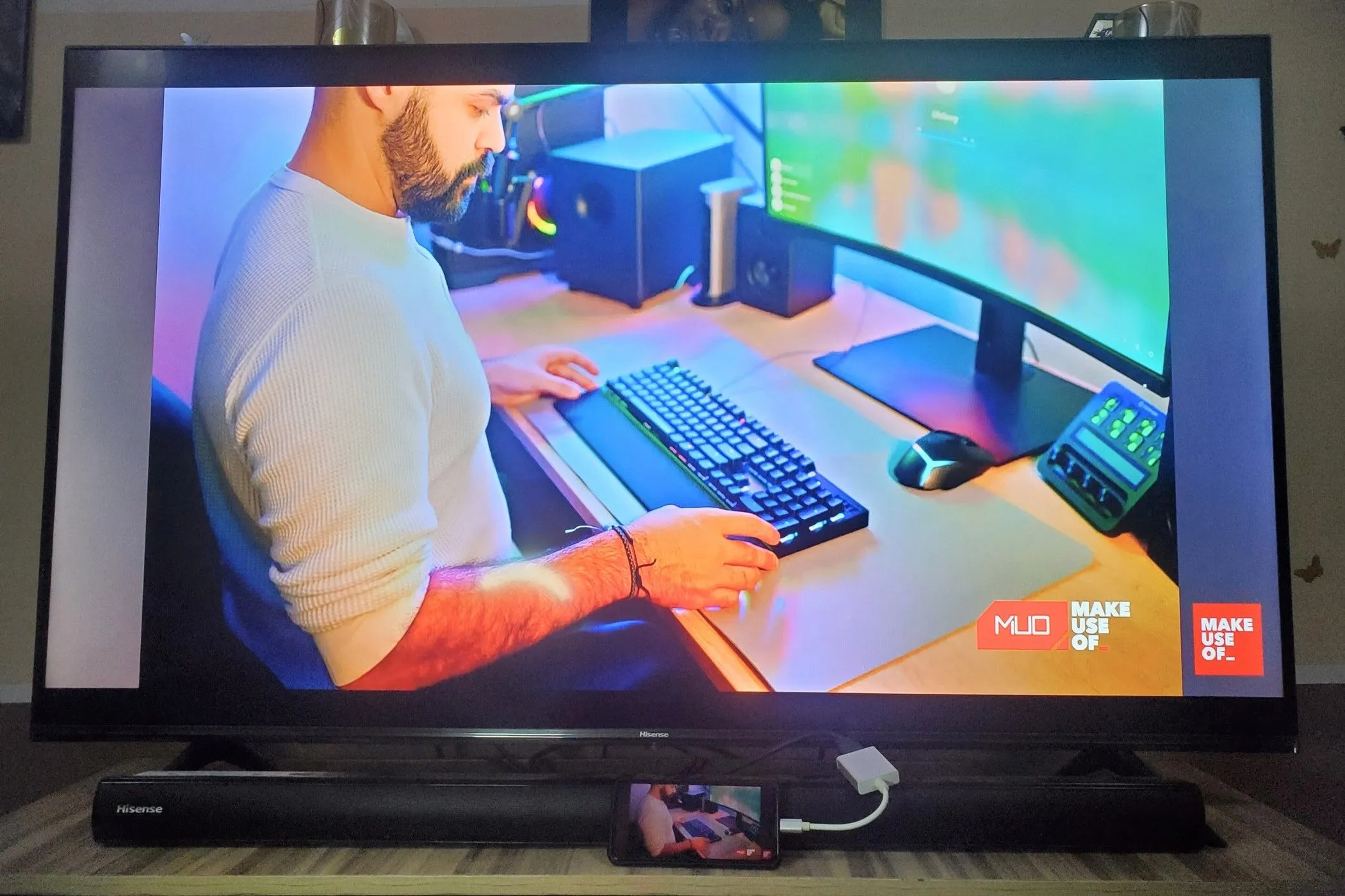 Điện thoại thông minh kết nối với TV qua adapter USB-C sang HDMI, hiển thị màn hình điện thoại đang được nhân bản trên màn hình lớn.