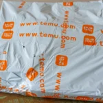 Gói hàng Temu trên bàn, thể hiện sự thay đổi chính sách giá