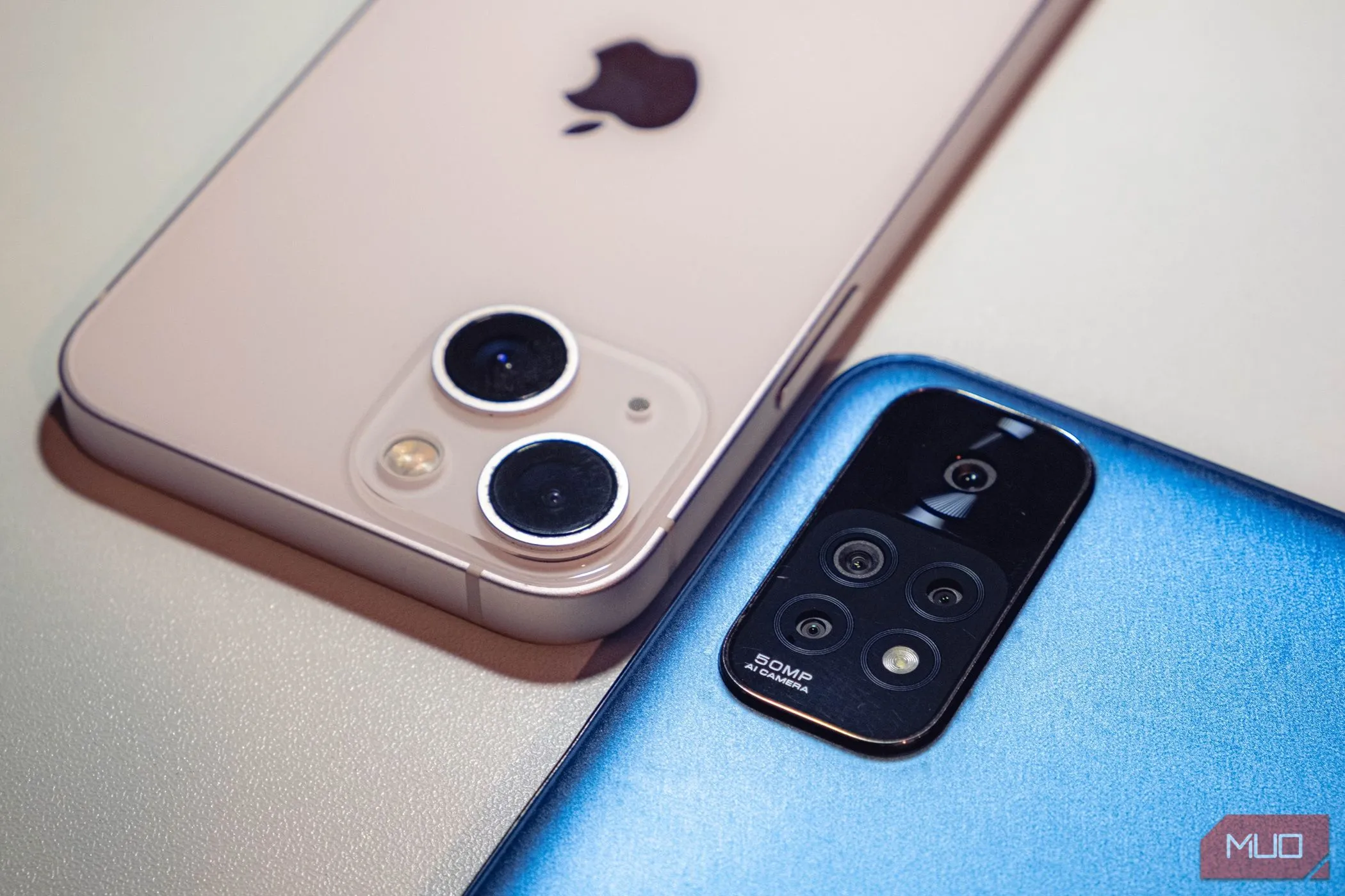Hai chiếc smartphone tầm trung màu xanh và hồng đặt úp, tượng trưng cho sự đa dạng và khả năng đáp ứng nhu cầu tốt của dòng điện thoại này.