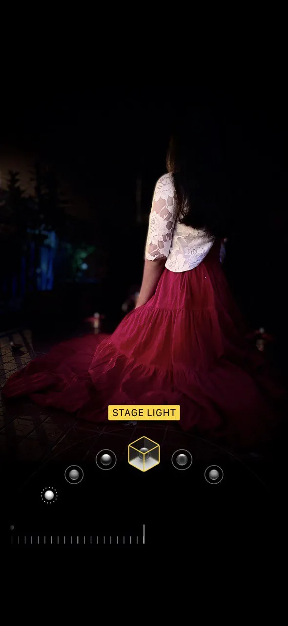 Hình ảnh chân dung iPhone với chế độ Stage Light, tách biệt chủ thể khỏi nền đen hoàn toàn tạo hiệu ứng sân khấu.
