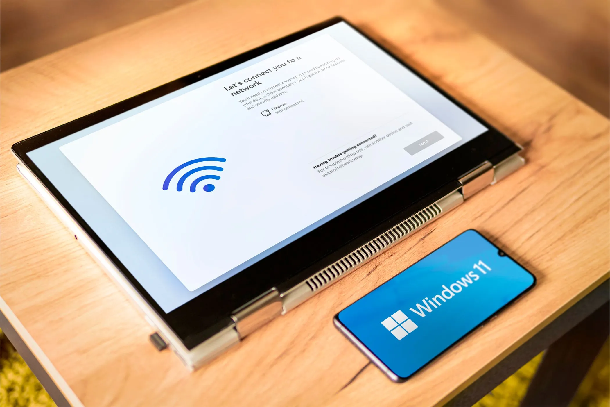 Hình ảnh logo Windows 11 trên laptop và điện thoại, minh họa khả năng biến điện thoại Android thành màn hình phụ cho máy tính.