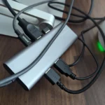 Hình ảnh minh họa dock USB-C nằm ngang với nhiều dây cáp kết nối, tạo sự lộn xộn trên bàn làm việc.