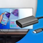 Hình ảnh một người đang cầm điện thoại kết nối với màn hình thông qua adapter USB-C sang HDMI, minh họa việc chiếu màn hình điện thoại lên màn hình lớn.