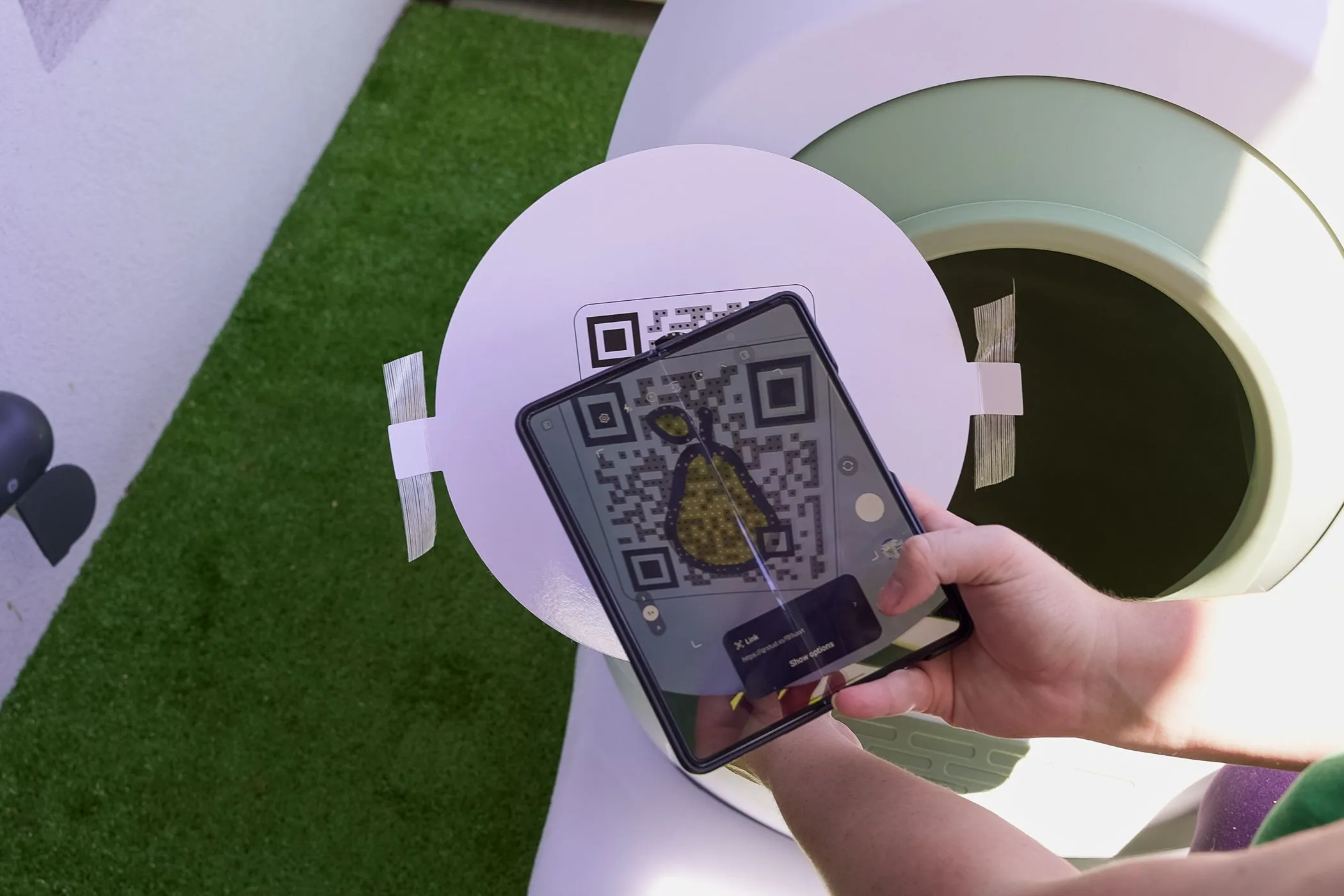 Hình ảnh người dùng đang quét mã QR trên tường công cộng, cần kiểm tra ngữ cảnh