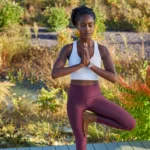 Hình ảnh người phụ nữ tập yoga với đồng hồ Garmin trên cổ tay, thể hiện khả năng theo dõi dữ liệu sức khỏe và thể chất của thiết bị.