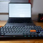 Keychron K8 Max màu đen trên bàn làm việc cạnh MacBook Pro