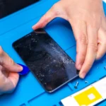 Kỹ thuật viên đang cẩn thận cạy mở smartphone để sửa chữa tại trung tâm bảo hành