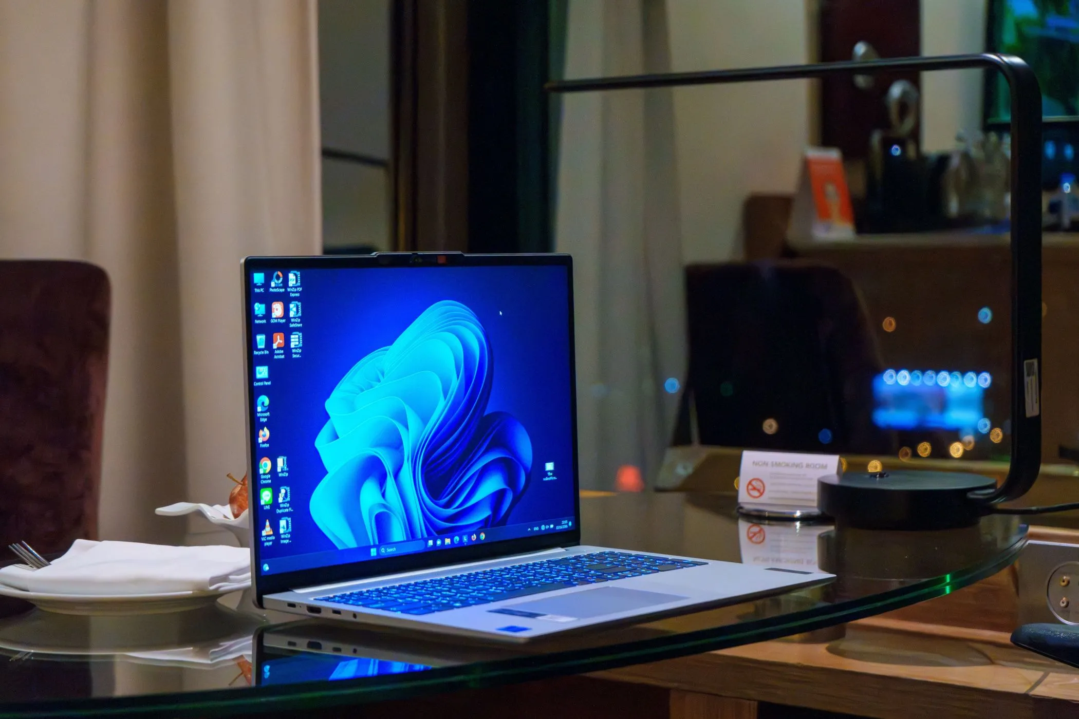 Laptop Windows trên bàn kính với các biểu tượng trên màn hình