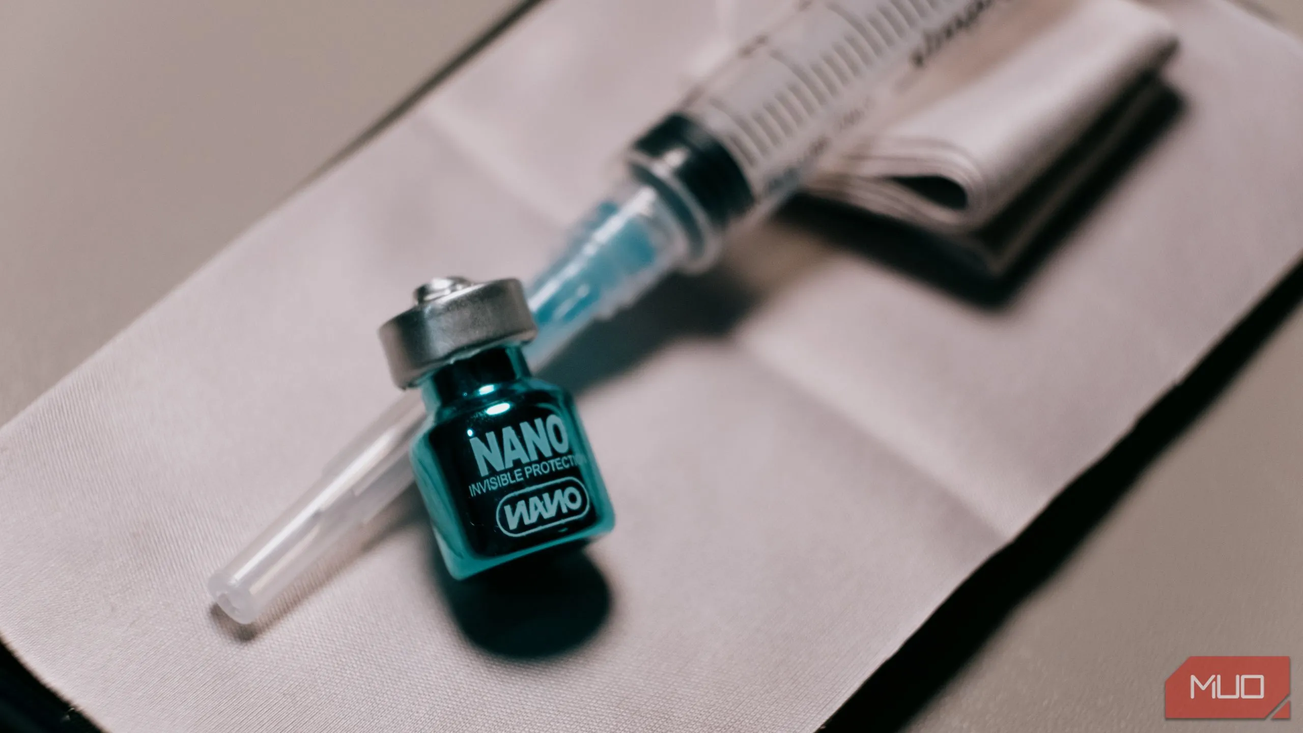 Lọ dung dịch phủ nano oleophobic và ống tiêm, chuẩn bị cho quá trình thử nghiệm lớp phủ bảo vệ màn hình điện thoại.