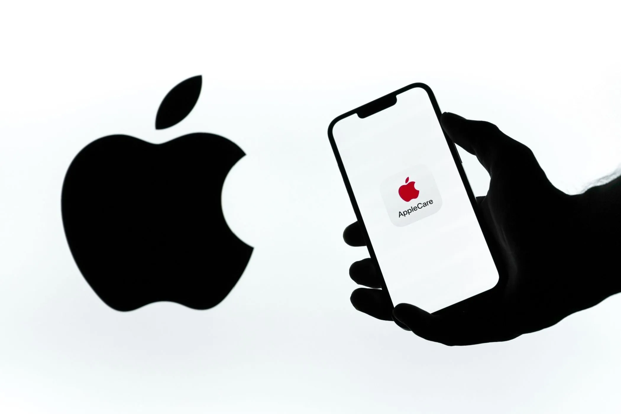 Logo AppleCare+ trên điện thoại cạnh logo Apple