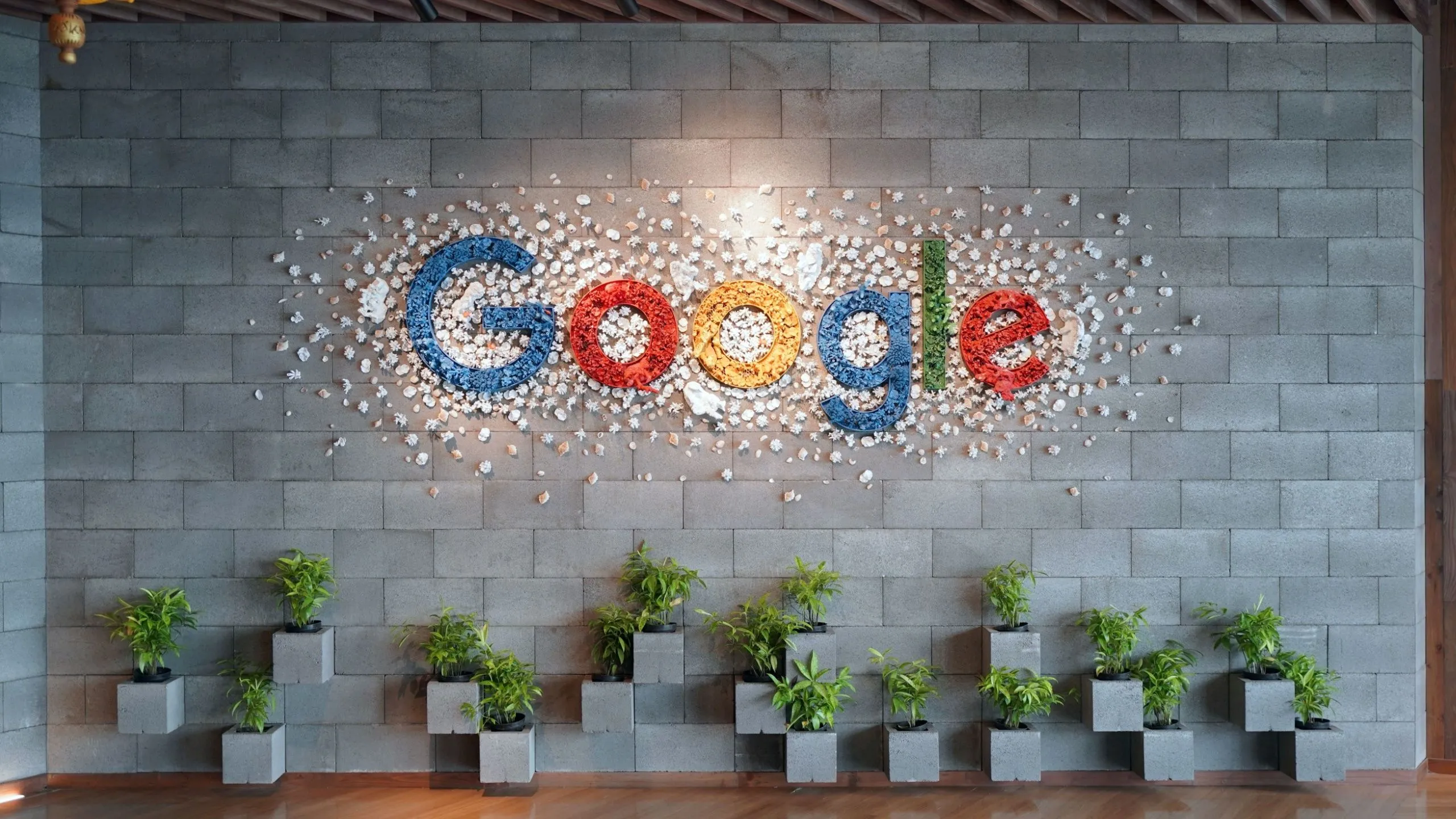 Logo Google trên tường văn phòng, biểu tượng đồng bộ hóa liền mạch của Chromebook với hệ sinh thái Google