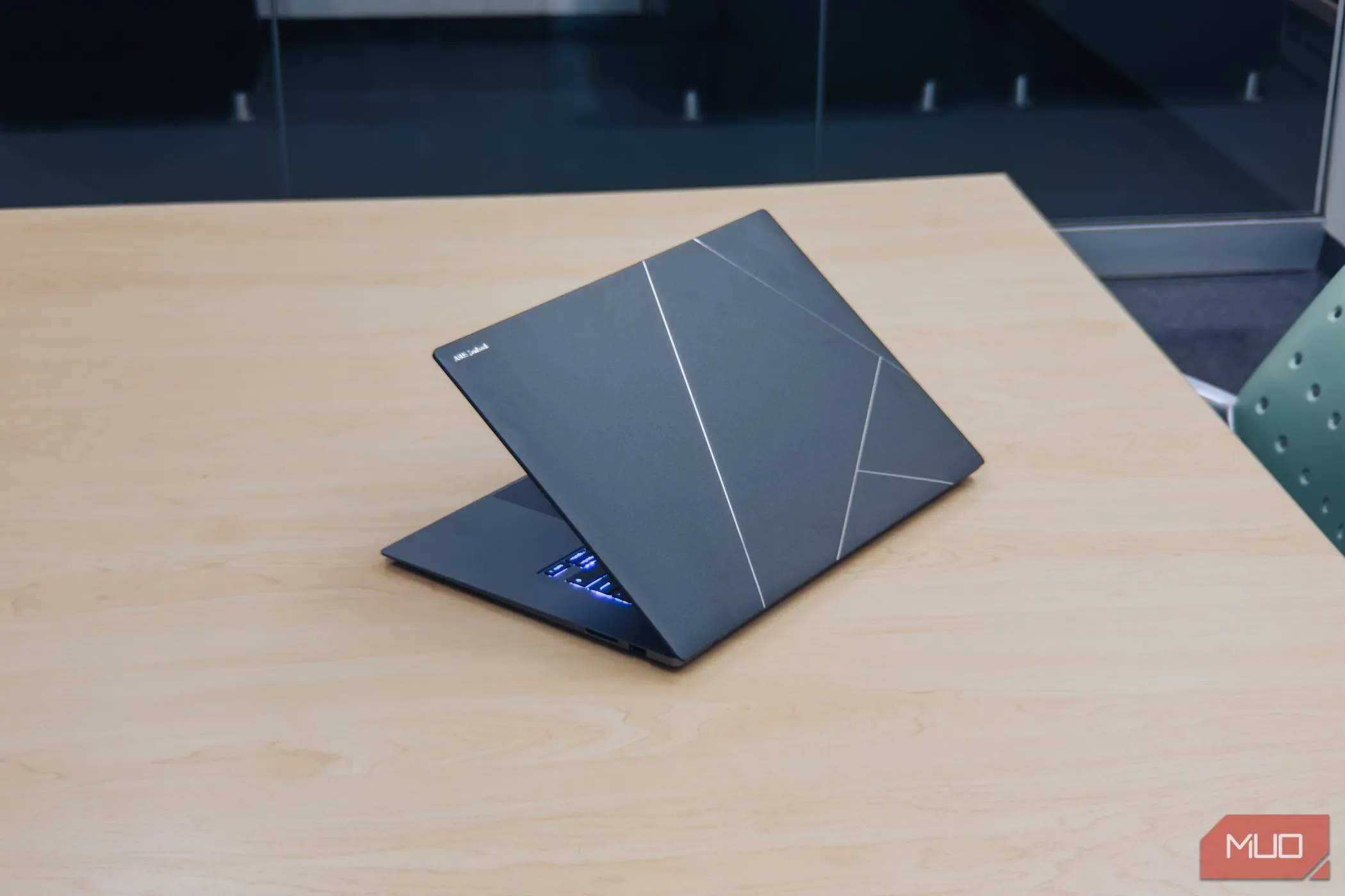 Mặt lưng ASUS Zenbook S 16 OLED với lớp hoàn thiện Ceraluminum trên bàn gỗ