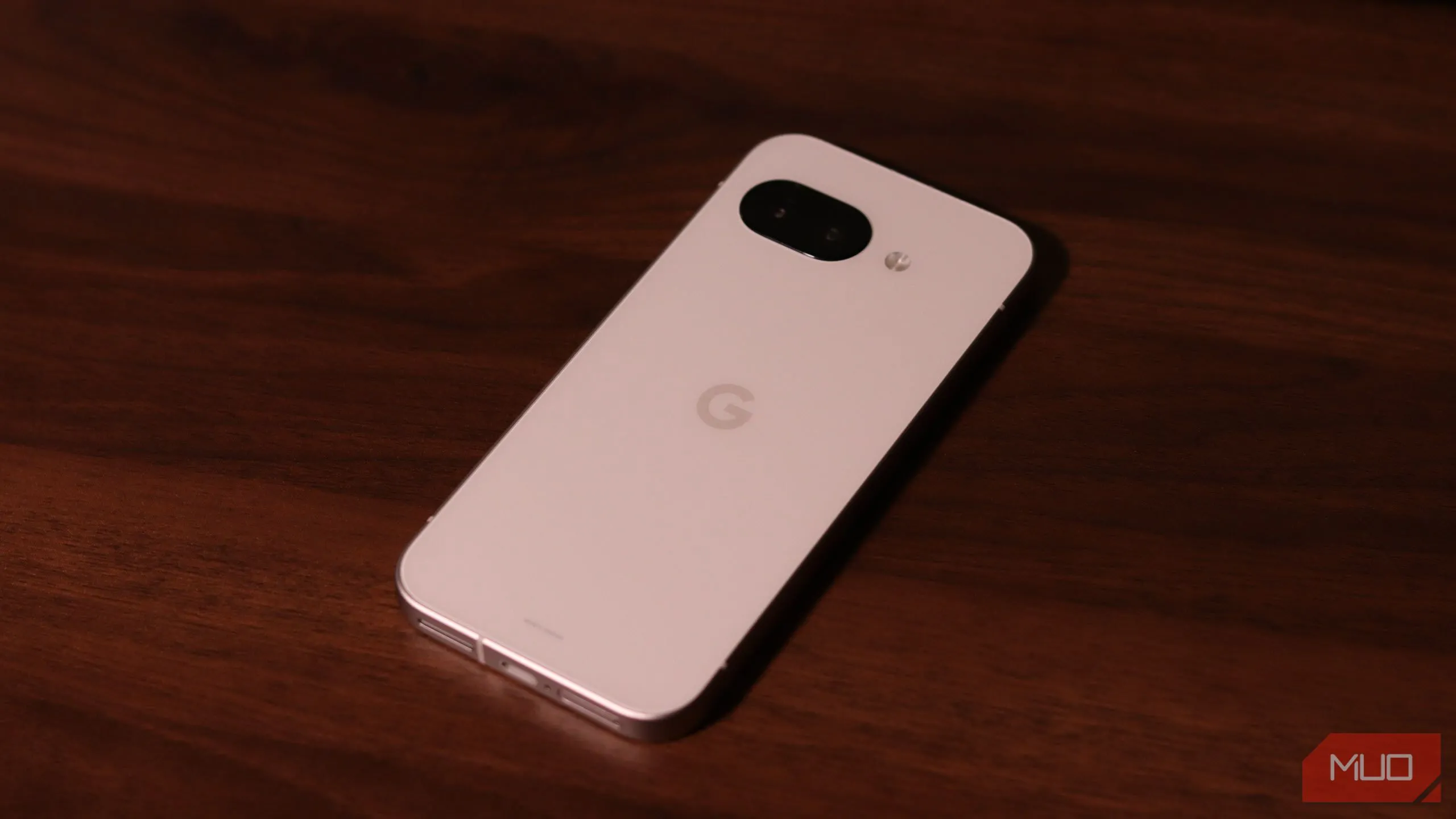 Mặt lưng điện thoại Google Pixel 9a màu xanh lá đặt trên bề mặt gỗ