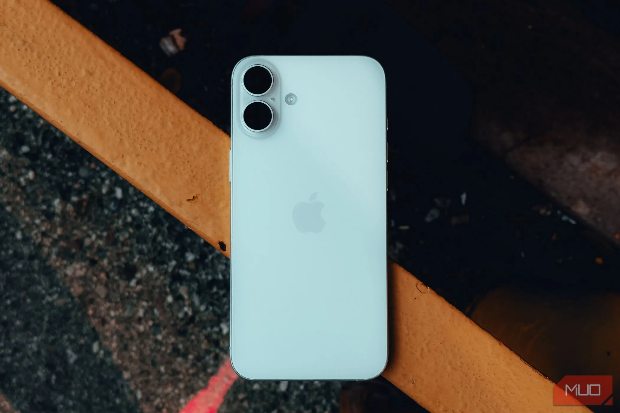 Mặt lưng iPhone 16 Plus trên lan can, minh họa tính năng chạm mặt lưng.