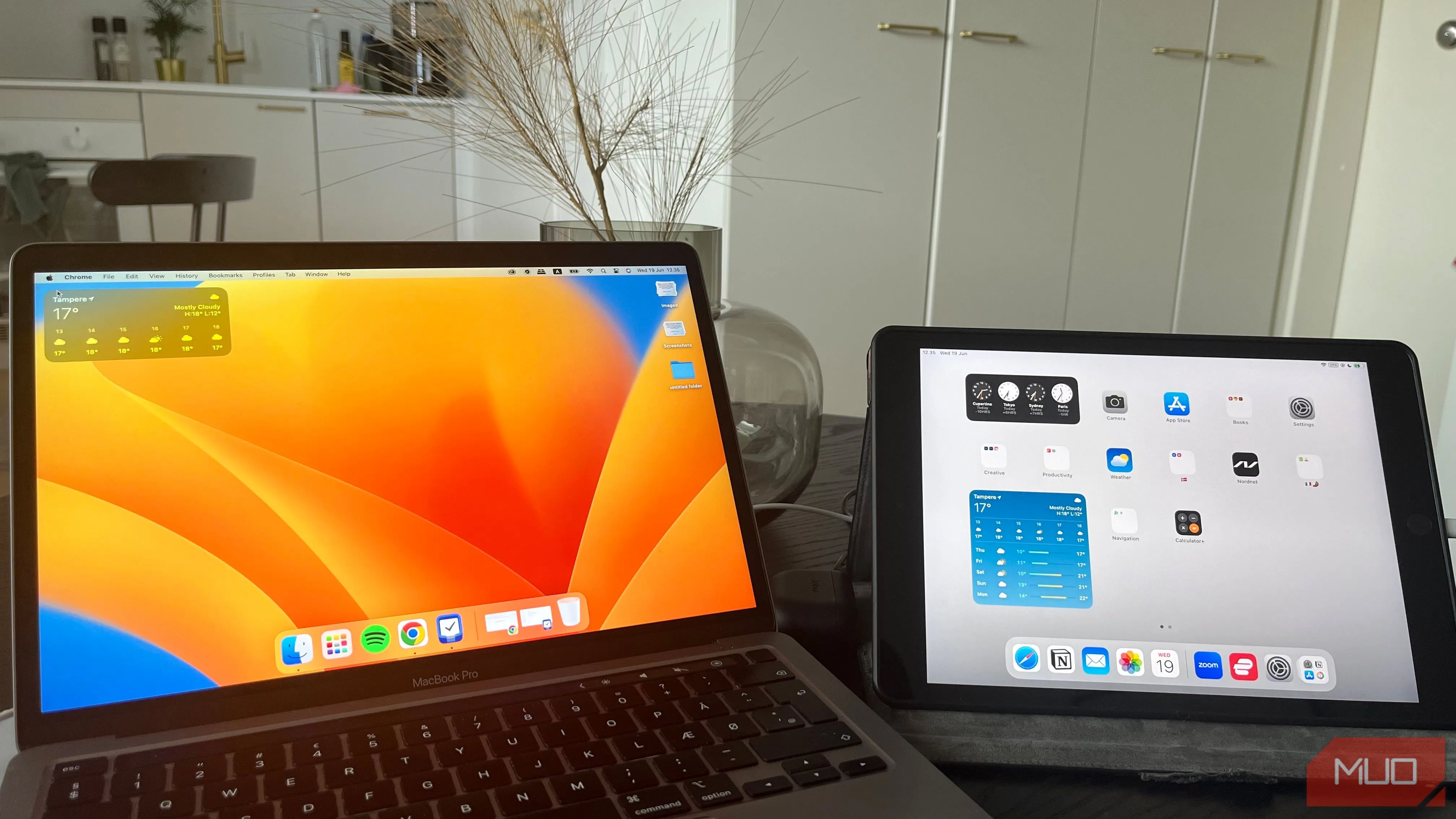 Máy tính MacBook và iPad đặt cạnh nhau trên bàn làm việc, cho thấy khả năng sử dụng iPad làm màn hình phụ hiệu quả
