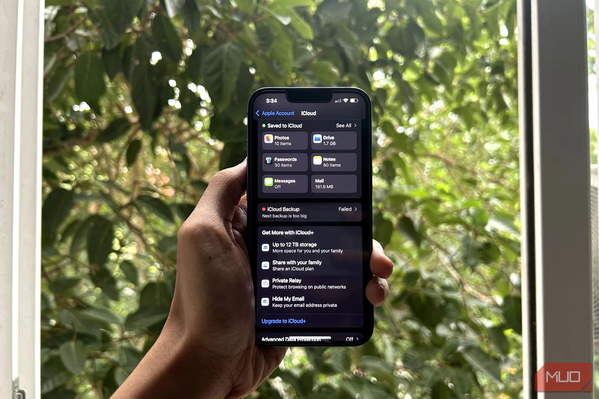 Một bàn tay đang cầm iPhone hiển thị menu iCloud mở