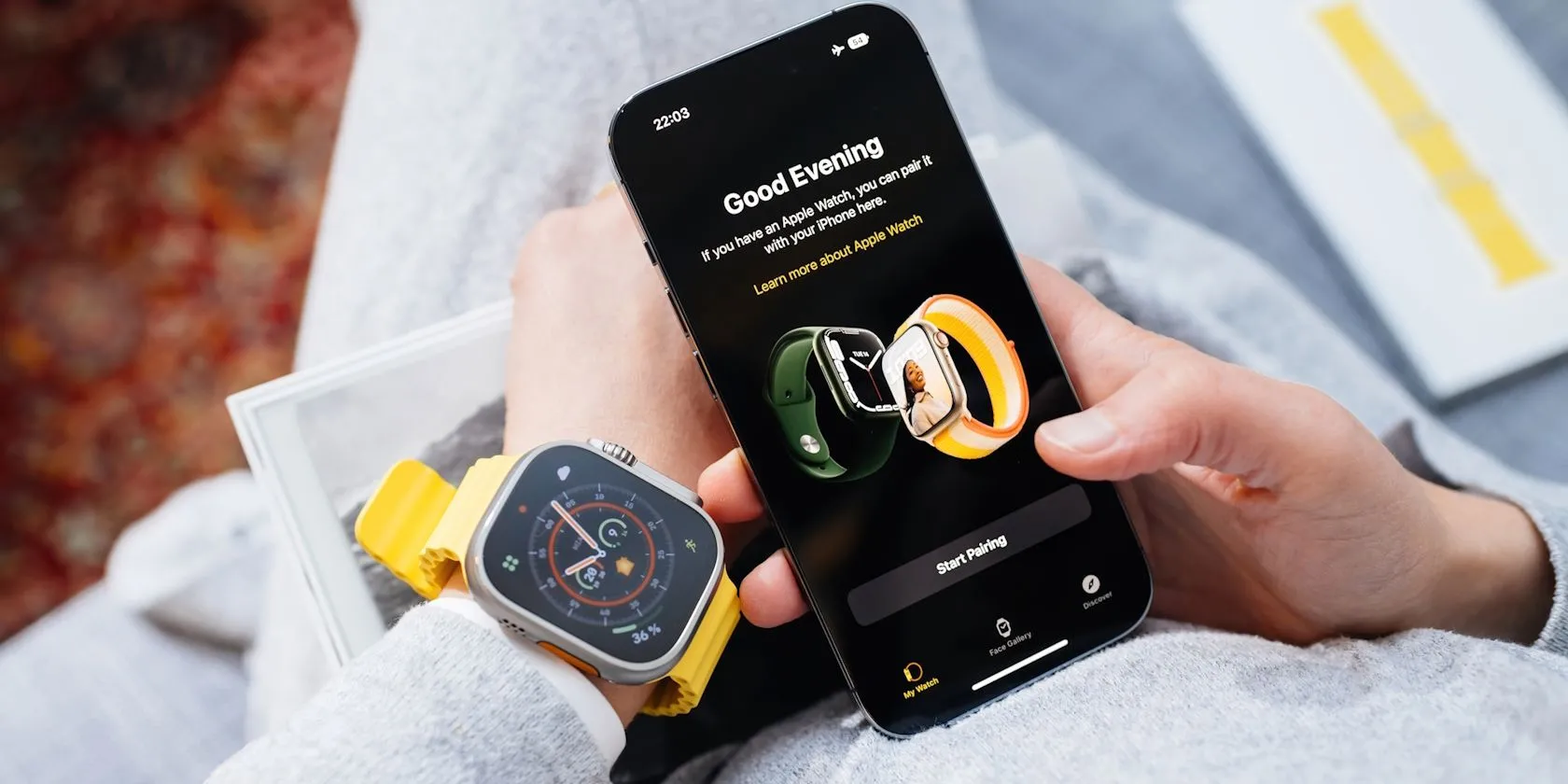 Một người đàn ông đang thực hiện ghép nối đồng hồ Apple Watch Ultra với điện thoại iPhone.