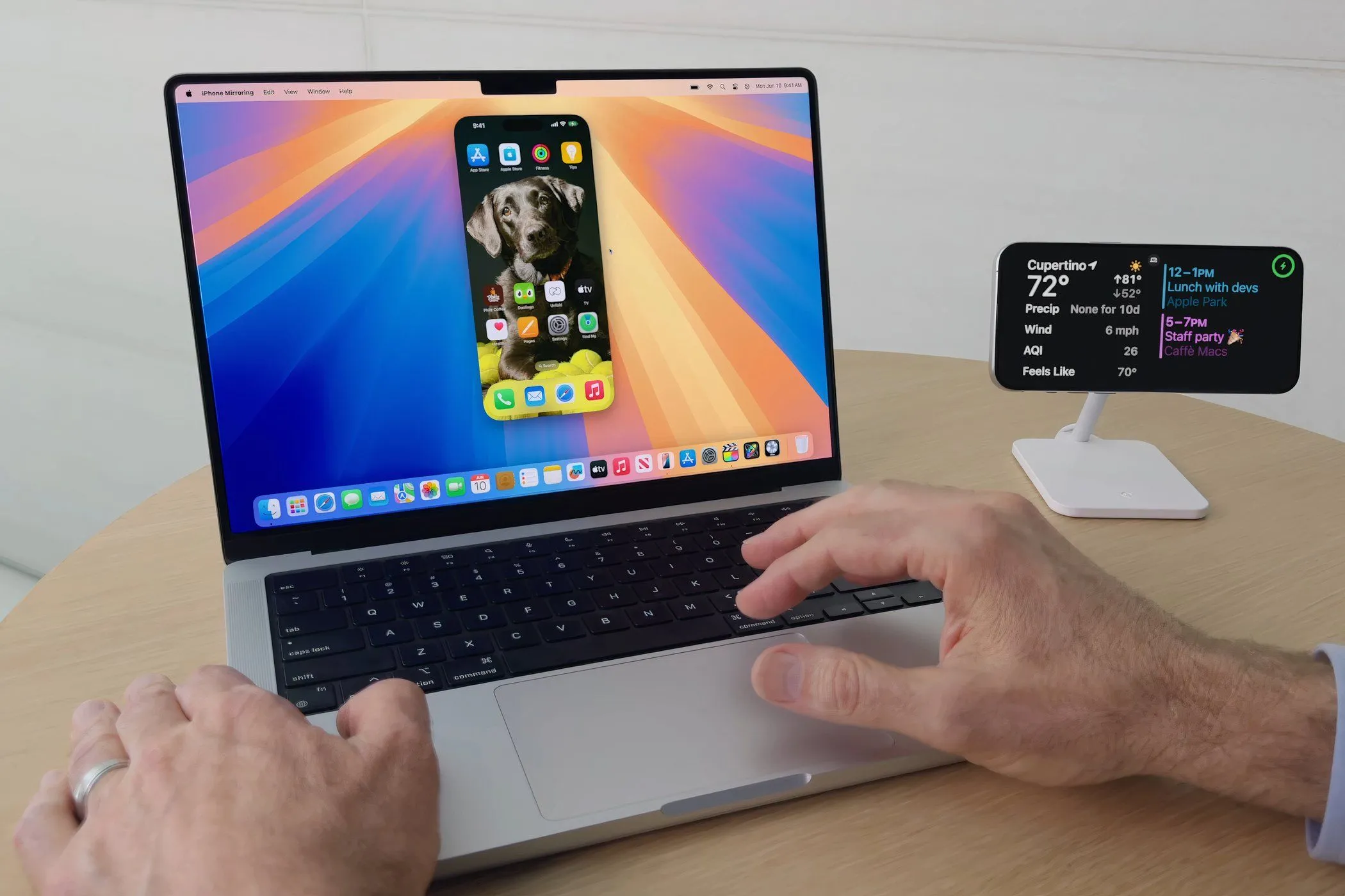Một người dùng MacBook Pro với tính năng iPhone Mirroring của macOS Sequoia đang hoạt động, cho phép điều khiển iPhone trực tiếp từ máy Mac.