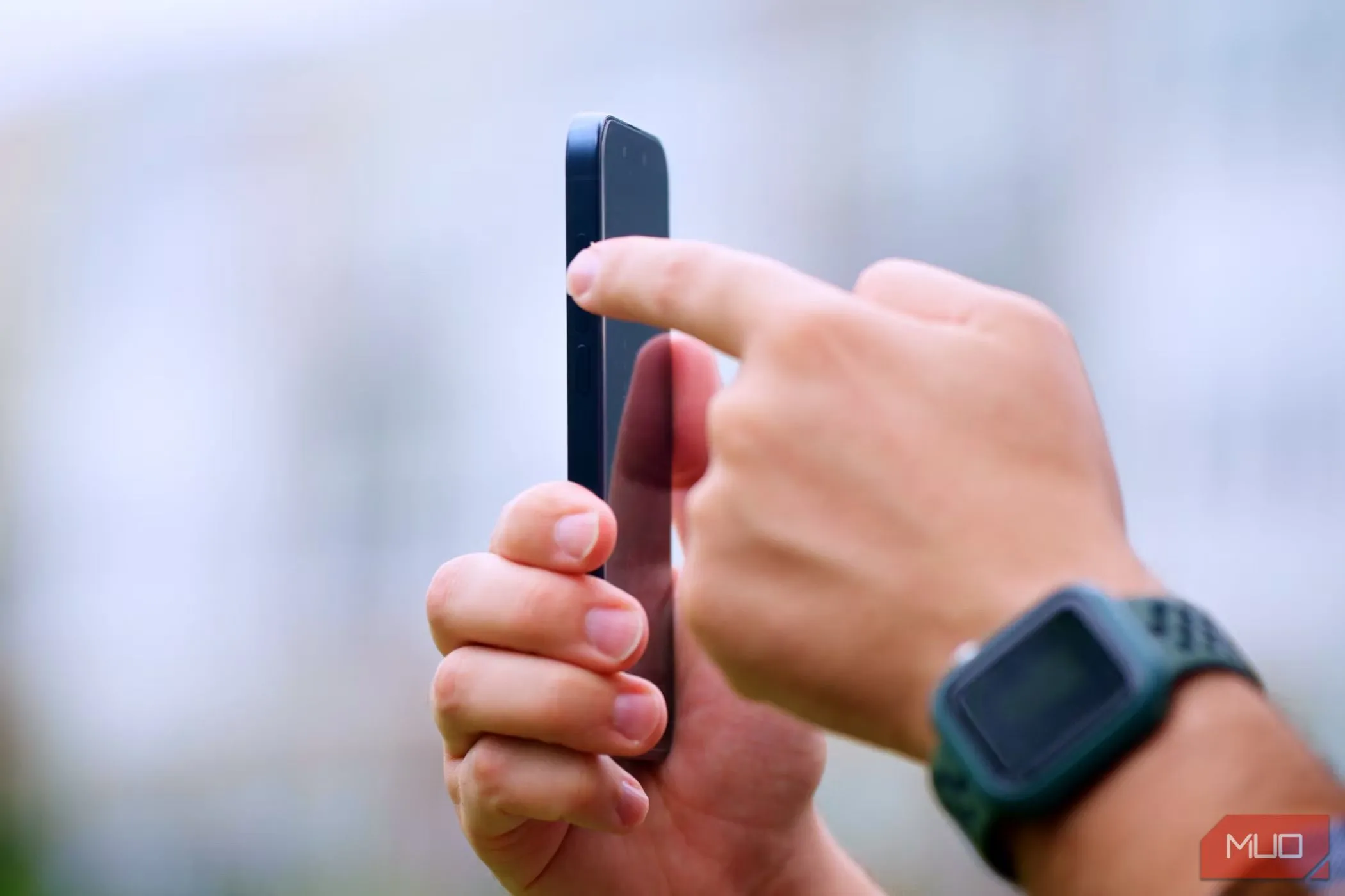 Người đàn ông cầm iPhone 15 Pro và tương tác với Action Button ở cạnh bên