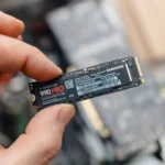 Người đàn ông cầm trên tay ổ cứng SSD Samsung 990 Pro, minh họa cho sự vượt trội của SSD so với ReadyBoost trong việc tăng tốc máy tính.