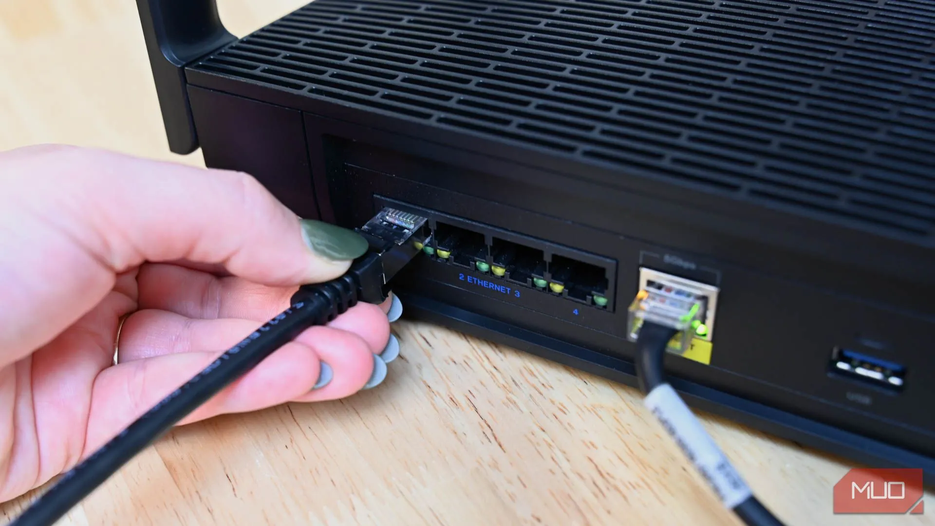 Người dùng cắm cáp Ethernet vào router du lịch để cải thiện tốc độ mạng khách sạn
