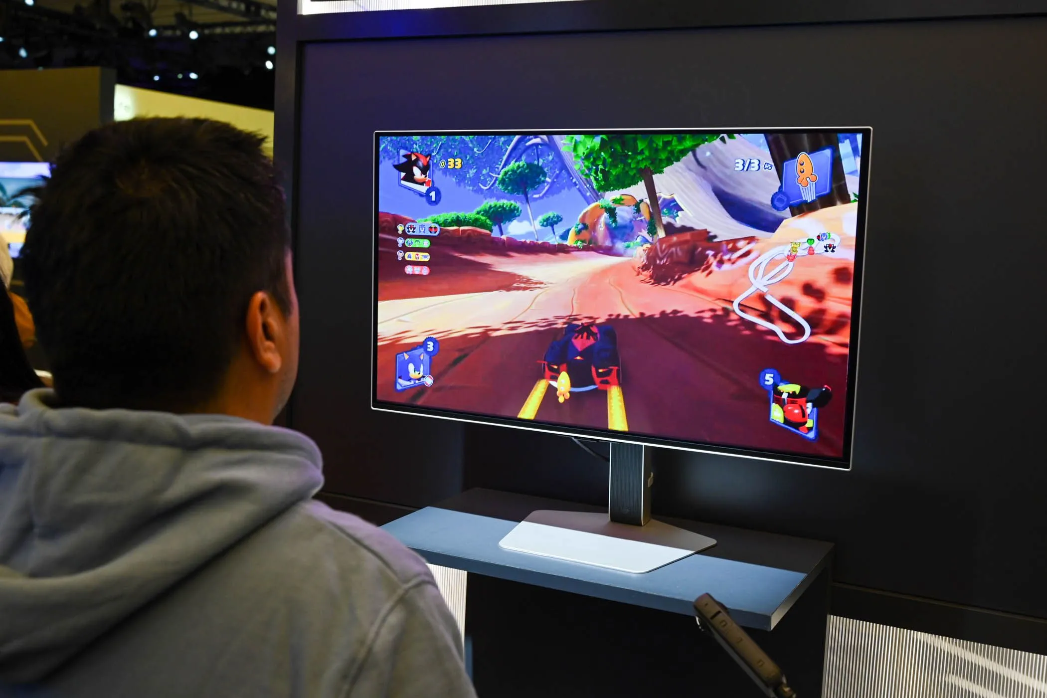 Người dùng đang trải nghiệm chơi game trên màn hình Odyssey OLED G8 32 inch tại sự kiện CES 2024, liên quan đến trải nghiệm công thái học khi sử dụng các kích thước màn hình khác nhau