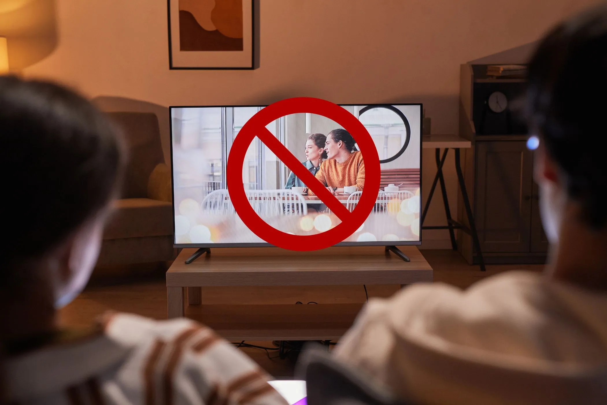 Người dùng xem TV với biểu tượng cấm trên màn hình, minh họa việc thiết bị khác chiếm băng thông khi kiểm tra tốc độ internet.