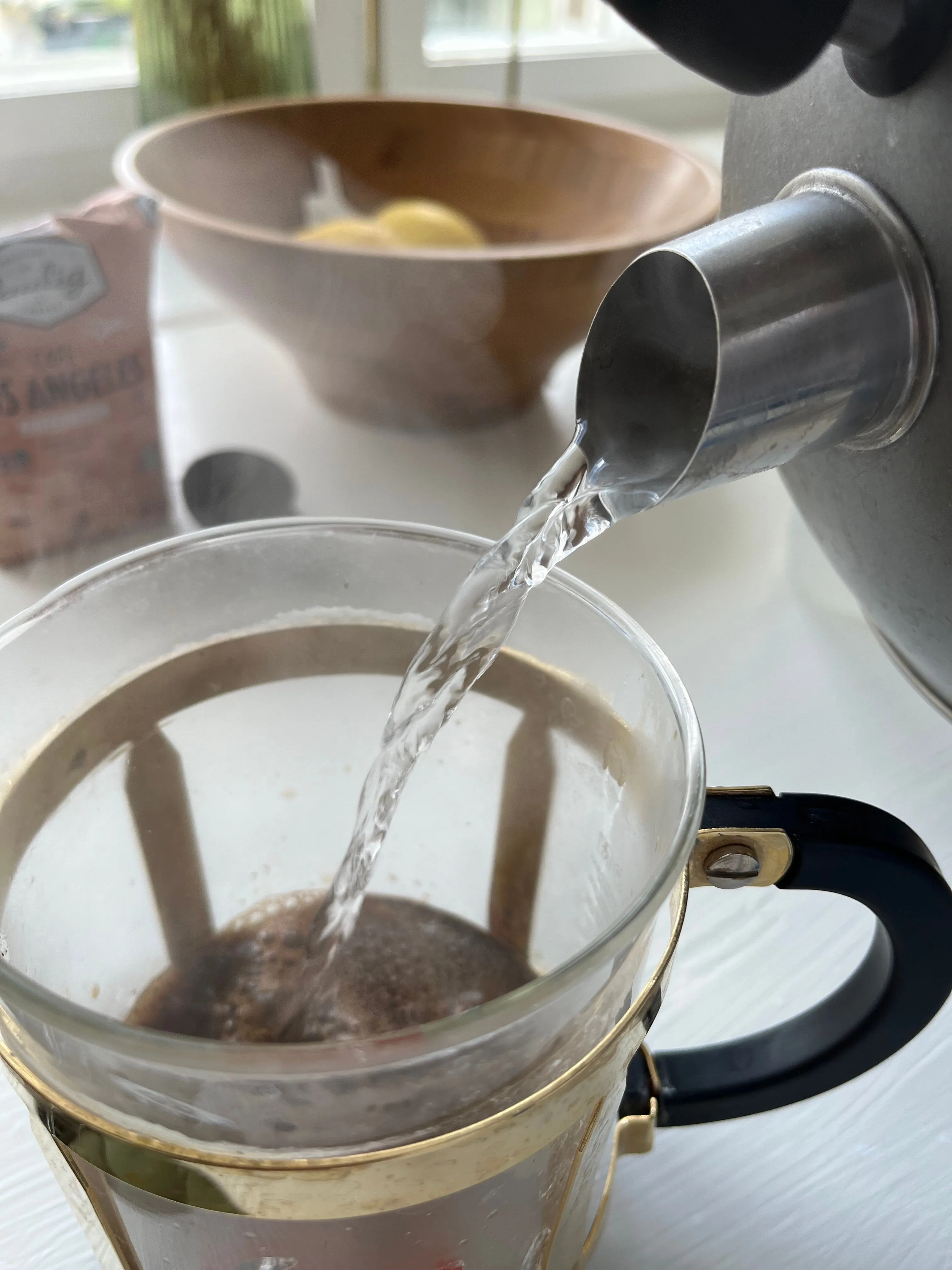 Nước được rót từ ấm vào bình pha cà phê