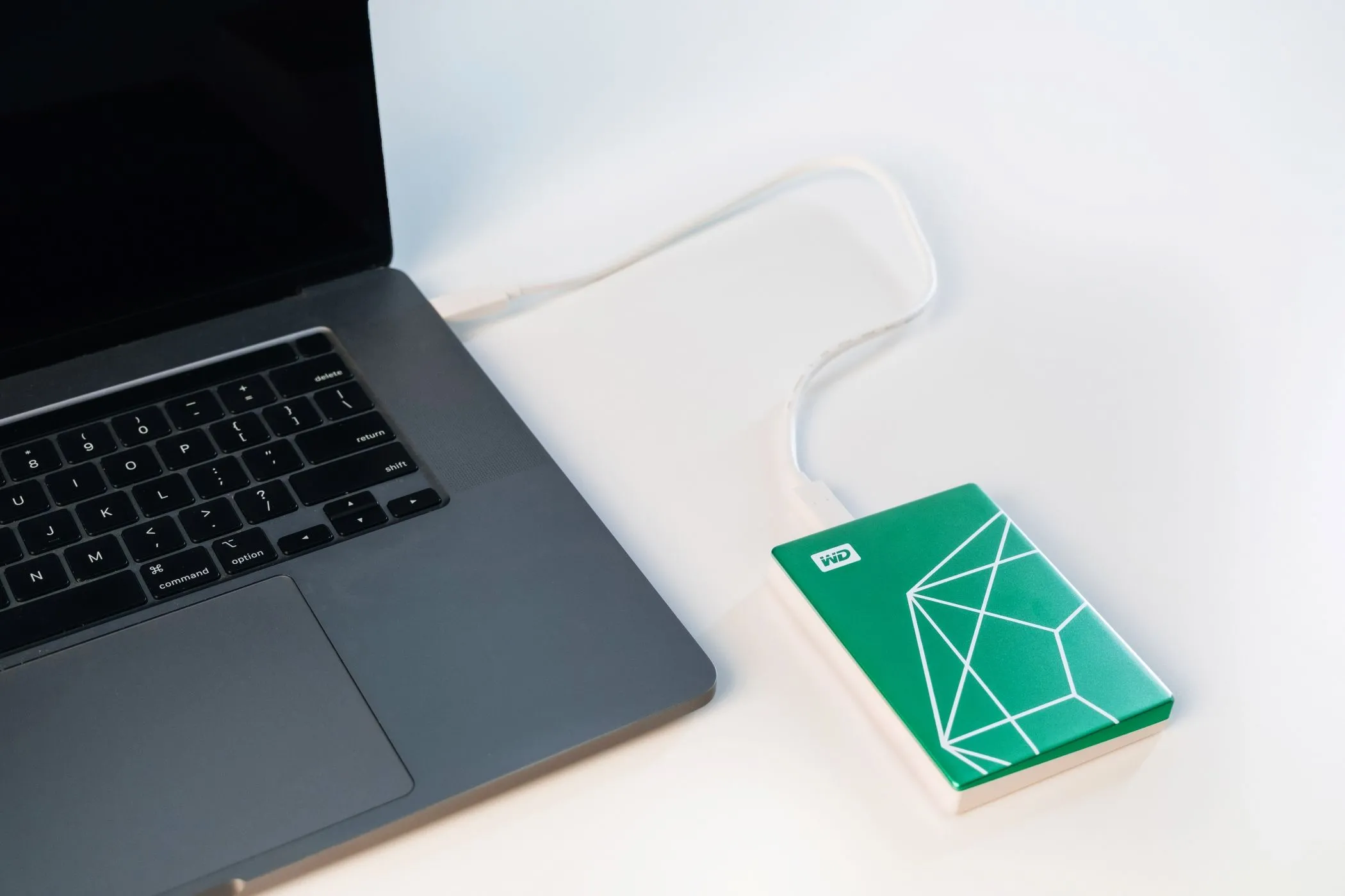 Ổ cứng WD My Passport Ultra Emerald Edition được kết nối với máy tính xách tay để sao lưu dữ liệu
