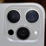 Ống kính camera iPhone bị bám bẩn rõ rệt với các vết dầu mỡ và vân tay.