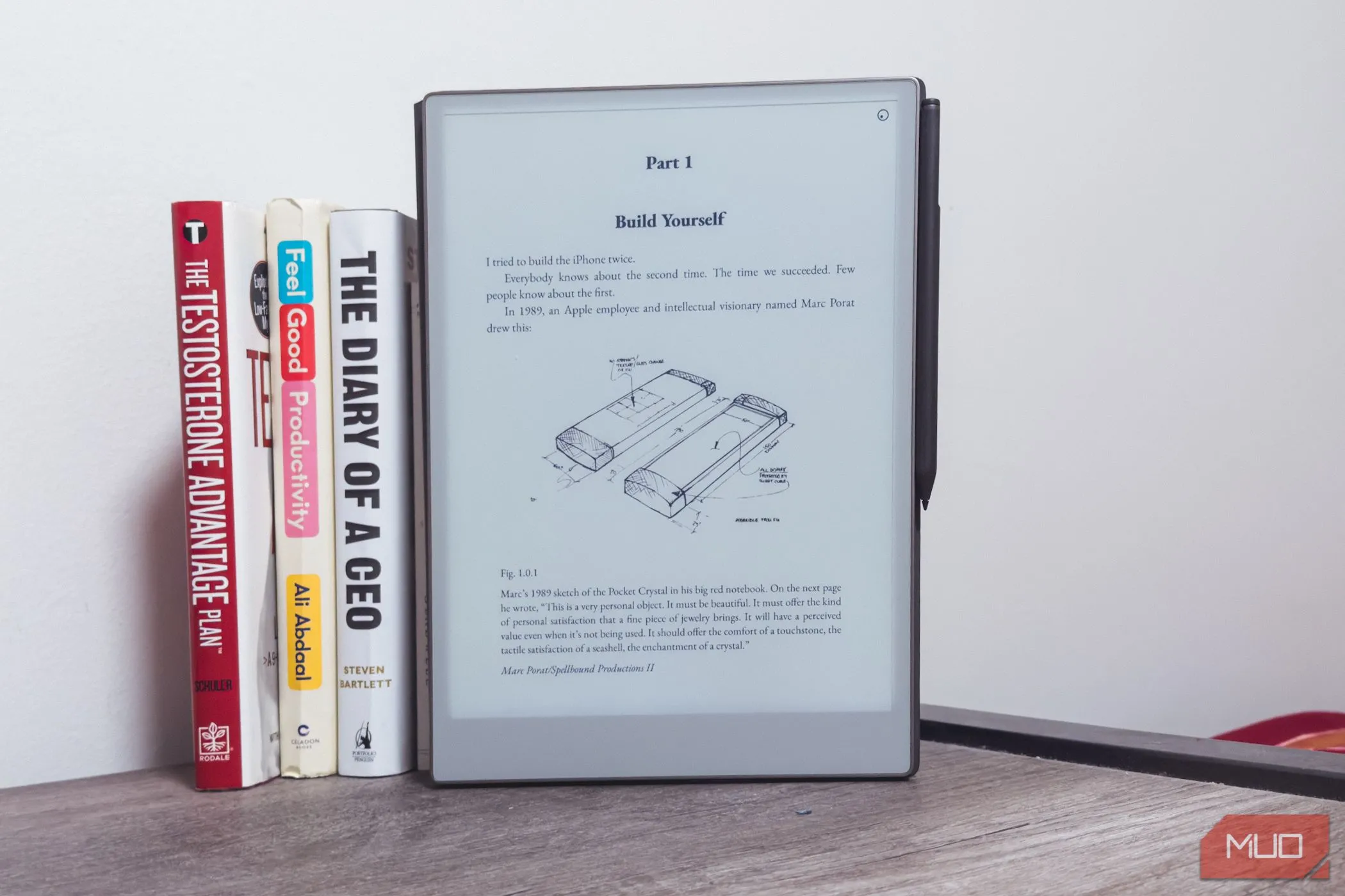 reMarkable Paper Pro đặt cạnh những cuốn sách trên bàn gỗ, thể hiện kích thước lớn hơn của tablet.