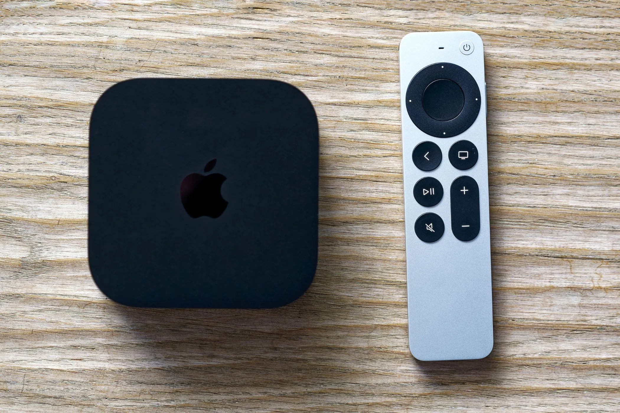 Thiết bị giải mã Apple TV 4K và điều khiển từ xa trên nền trắng