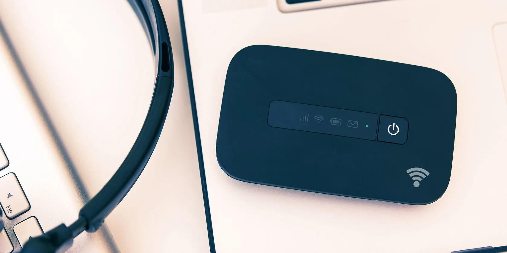 Thiết bị phát Wi-Fi di động (mobile hotspot) đặt cạnh laptop, đảm bảo kết nối ổn định khi làm việc từ xa