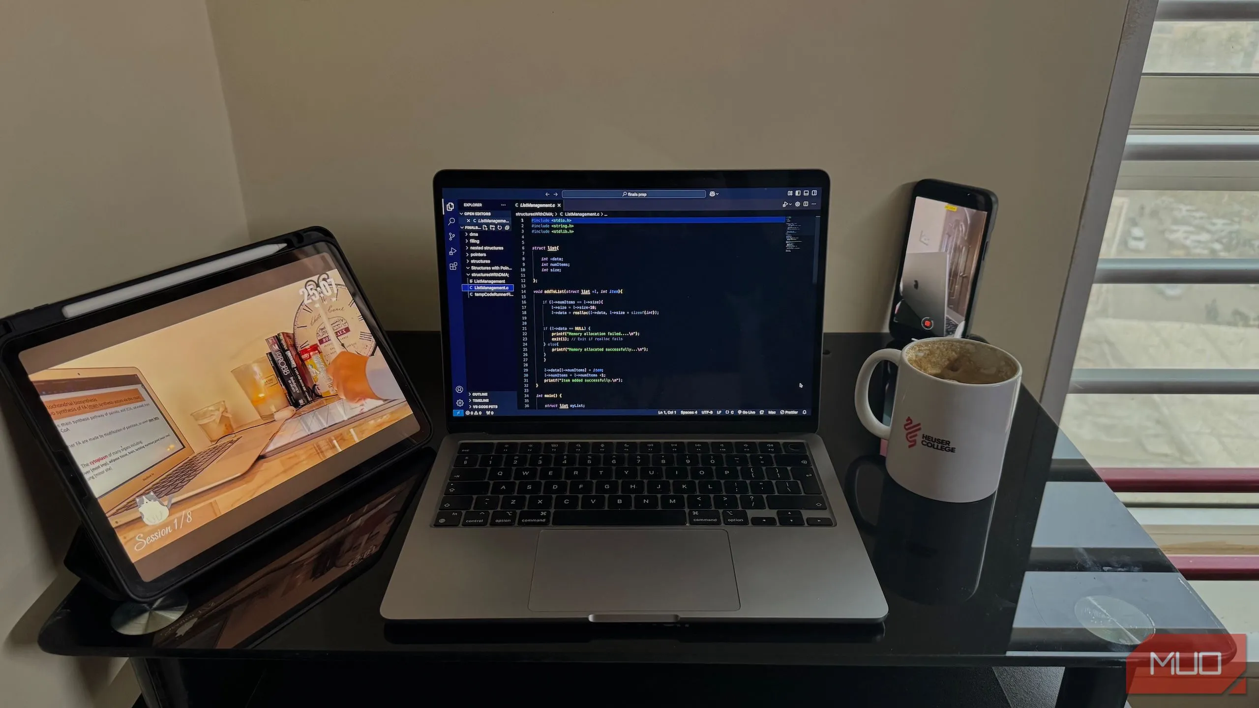 Thiết lập bàn làm việc với MacBook, iPad và điện thoại cố định trên giá đỡ, minh họa quá trình quay video time-lapse để nâng cao sự tập trung và năng suất.