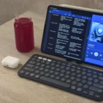 Thiết lập làm việc di động với iPad Air, bàn phím Logitech Pebble Keys 2 K380s, chuột ESR MagMouse và tai nghe AirPods trên bàn.